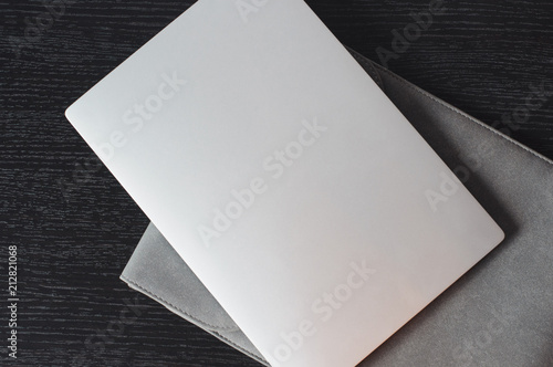 Top view on the silver laptop with grey case on the wooden desk. Minimalistic background