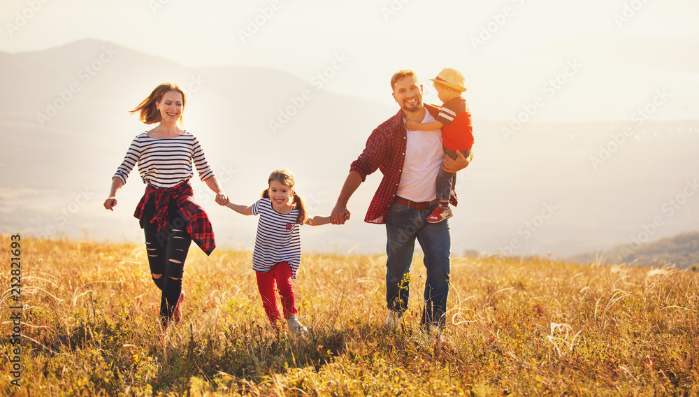 Happy family: mother, father, children son and daughter on sunset - obrazy, fototapety, plakaty 