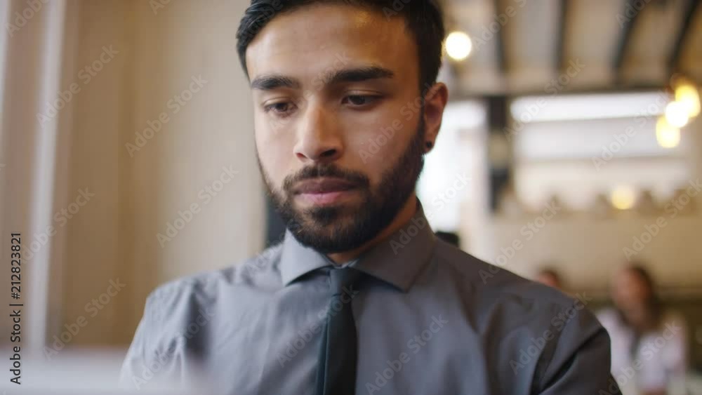 Professional business man using his laptop on a break in a coffee shop Professional business man using his laptop on a break in a coffee shop