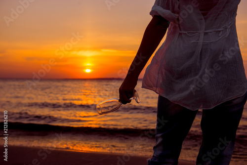 woman at sunset. Girl with glass on background setting sun. romantic date in the evening. girl on the beach. woman drinking from a wine glass on the beach. 