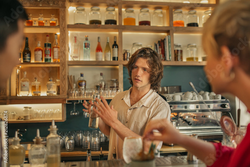 Bartender taking drink orders from customers in a trendy bar