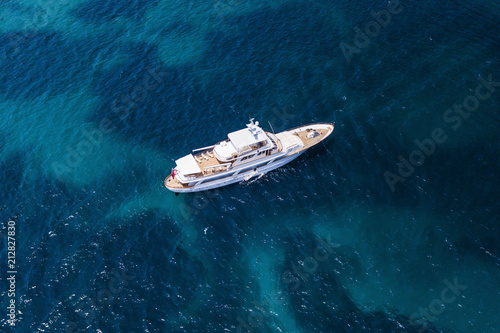 Aerial view of a luxury yacht on a turquoise and transparent sea. Emerald Coast, Mediterranean sea, Sardinia, Italy.