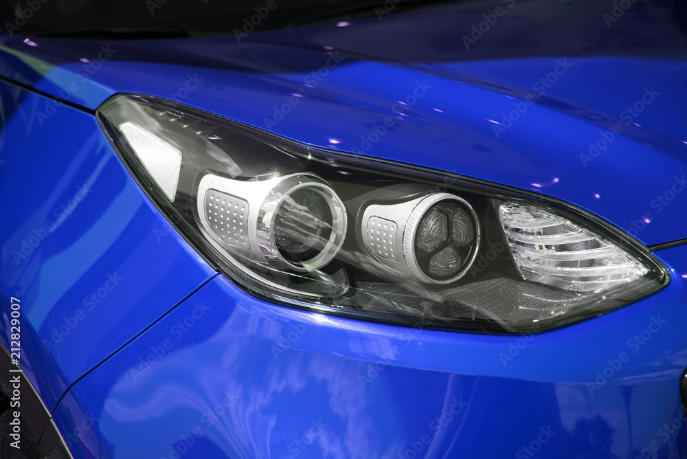 Right headlight of the new clean dark  blue color sports car