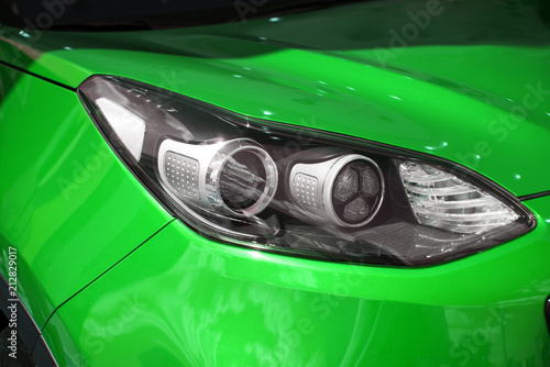 Right headlight of the new clean green color sports car © Евгений Вдовин