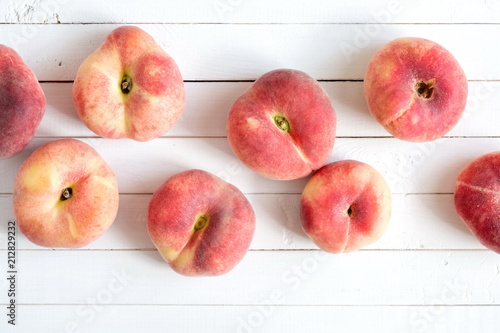 Ripe juicy peaches on a wooden white background. Fruit summer background. Flat lay, top view, copy space 
