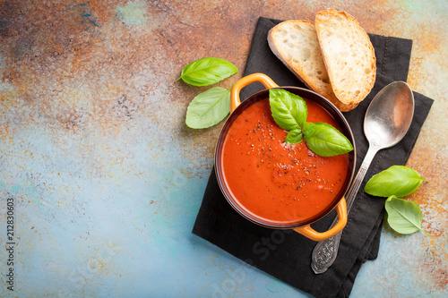 Fotografie Homemade tomato soup with Basil, toast and olive oil on the stone table