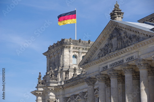 Exterior view of the historic building of Reichstag with a fluttering German flag