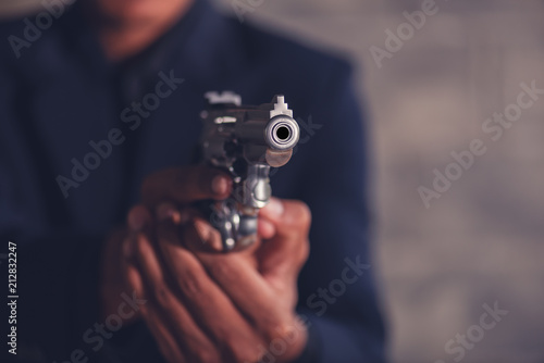 Mafia man holding a gun to intimidate