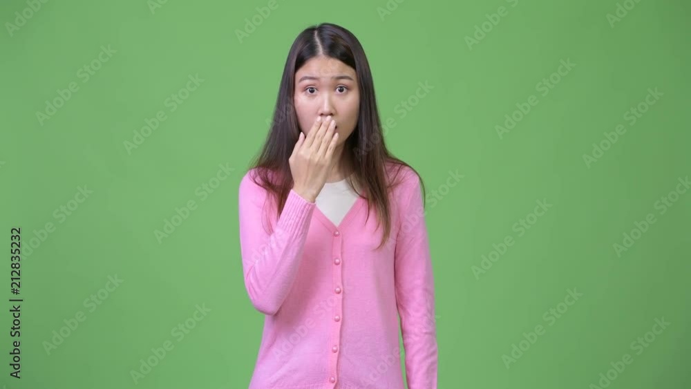 Young beautiful Asian woman looking shocked Young beautiful Asian woman looking shocked
