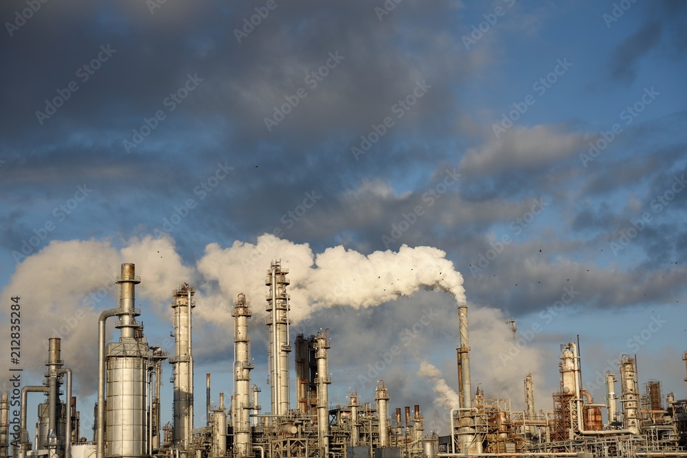 Carbon emissions, smokestack plume with blue sky and clouds. Petrochemical refinery, Corpus Christi.