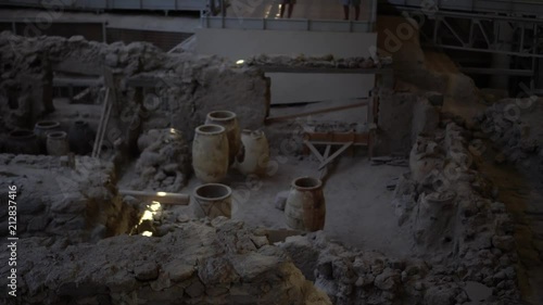 Jib shot of the Acrotiri ruins in Santorini, Greece. Amphorae are revealed as the camera rises over a wall. photo