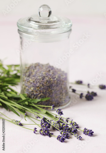 Fototapeta Naklejka Na Ścianę i Meble -  Glass jar with dried lavender and fresh lavender flowers on pink background
