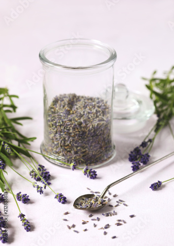 Fototapeta Naklejka Na Ścianę i Meble -  Glass jar with dried lavender and fresh lavender flowers on pink background