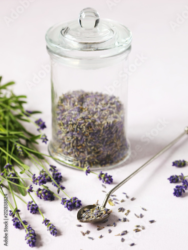 Fototapeta Naklejka Na Ścianę i Meble -  Glass jar with dried lavender and fresh lavender flowers on pink background