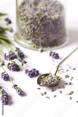 Fototapeta Naklejka Na Ścianę i Meble -  Glass jar with dried lavender and fresh lavender flowers on pink background