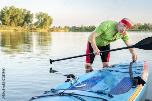 senior paddler with stand up paddleboard