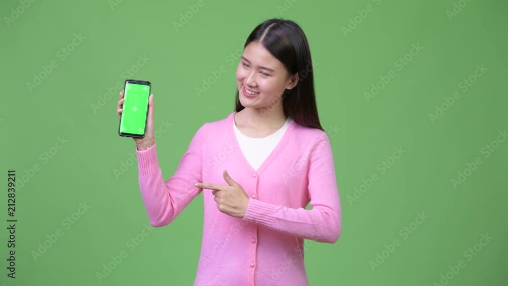 Young beautiful Asian woman showing phone Young beautiful Asian woman showing phone