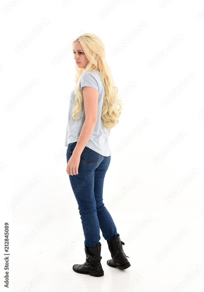 full length portrait of blonde girl wearing casual blue shirt and jeans, standing pose with back to the camera. isolated on white studio background. full length portrait of blonde girl wearing casual blue shirt and jeans, standing pose with back to the camera. isolated on white studio background.