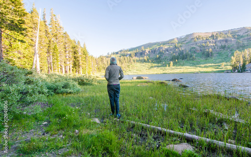 Girl Standing and Looking at Beautiful Mountain Lake