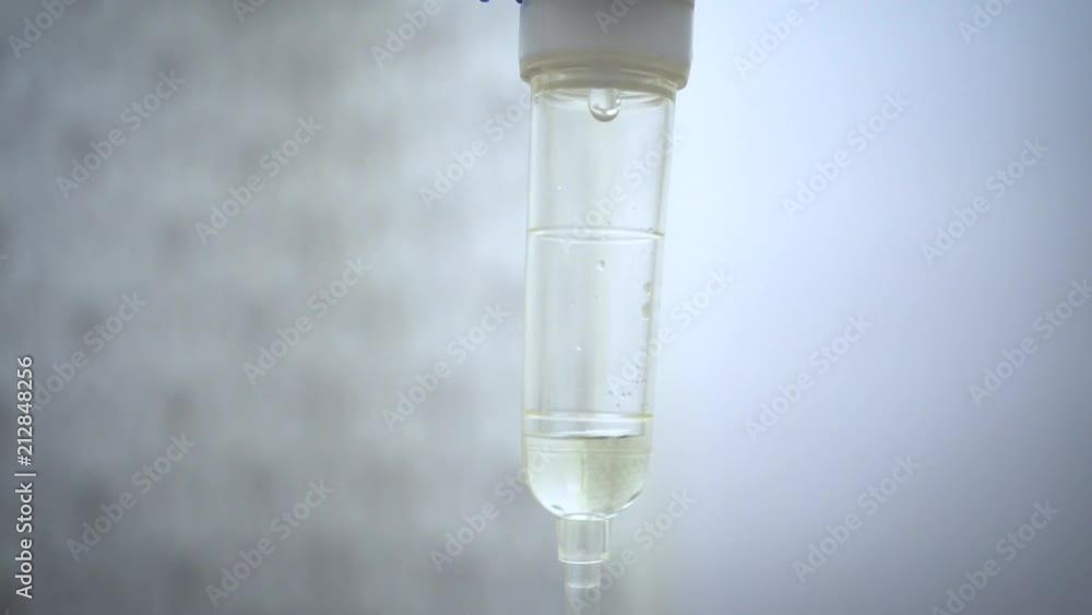 Close up of set IV saline solution dripping in hospital room Close up of set IV saline solution dripping in hospital room