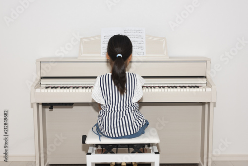 電子ピアノを弾く女の子の後ろ姿 photo
