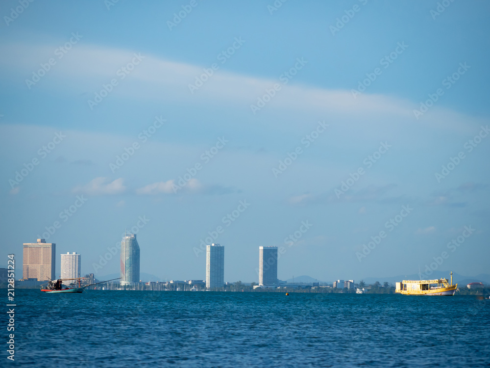 old boat floating on the sea with high building and city background