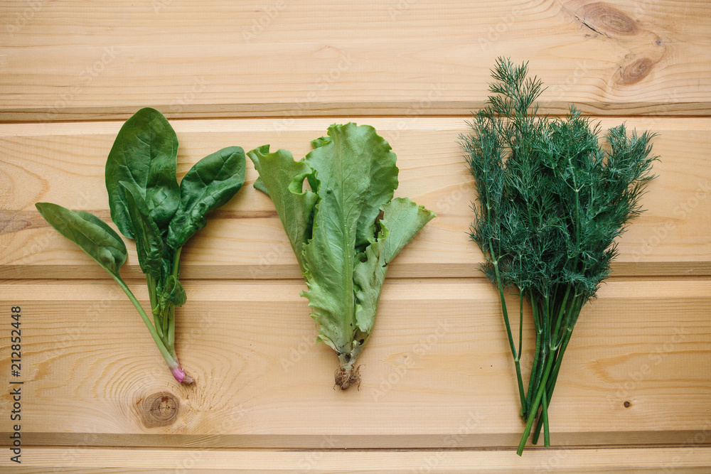 Spinach, green salad and dill on a wooden surface. Mix of greens. Healthy foods Spinach, green salad and dill on a wooden surface. Mix of greens. Healthy foods