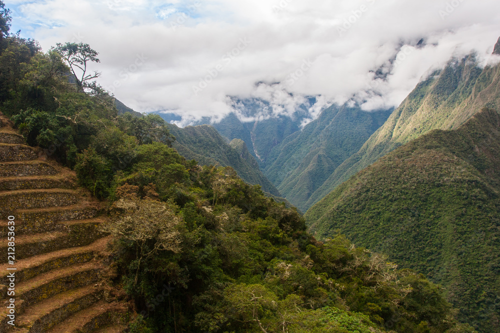 Obraz premium Landscape view of ancient Inca agriculture terrace with mountains and clouds on the background. Machu Picchu. Peru. South America. No people.