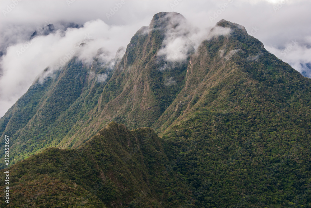 Beautiful wallpaper of the green Andes mountains with clouds above the peak on the Inca Trail to Machu Picchu in Peru.