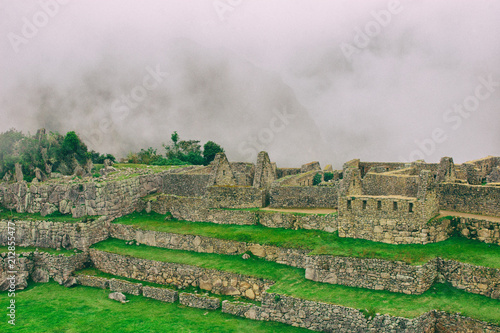 The day start with intense mist in the air in Machu Picchu. The historic archaeological site in a mysterious ambience. Beautiful wallpaper image.