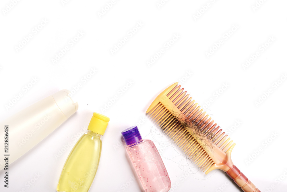 Comb with hair and shampoo on white background Comb with hair and shampoo on white background