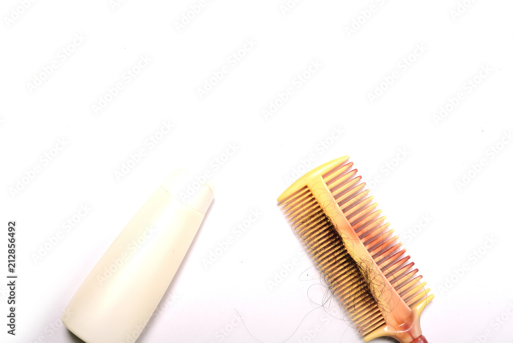 Comb with hair and shampoo on white background Comb with hair and shampoo on white background