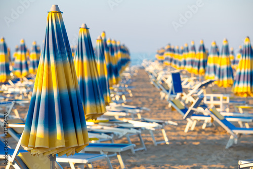 Blue and yellow umbrellas on beach photo