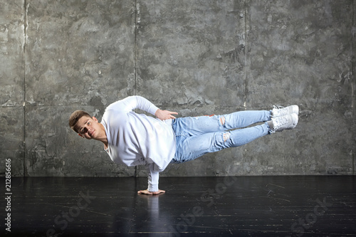 Handsome man dancer dancing. Man stands on hand in a dance pose.