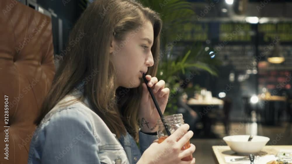 Young girl drinking cocktail sitting in cafe
Young girl drinking cocktail sitting in cafe
