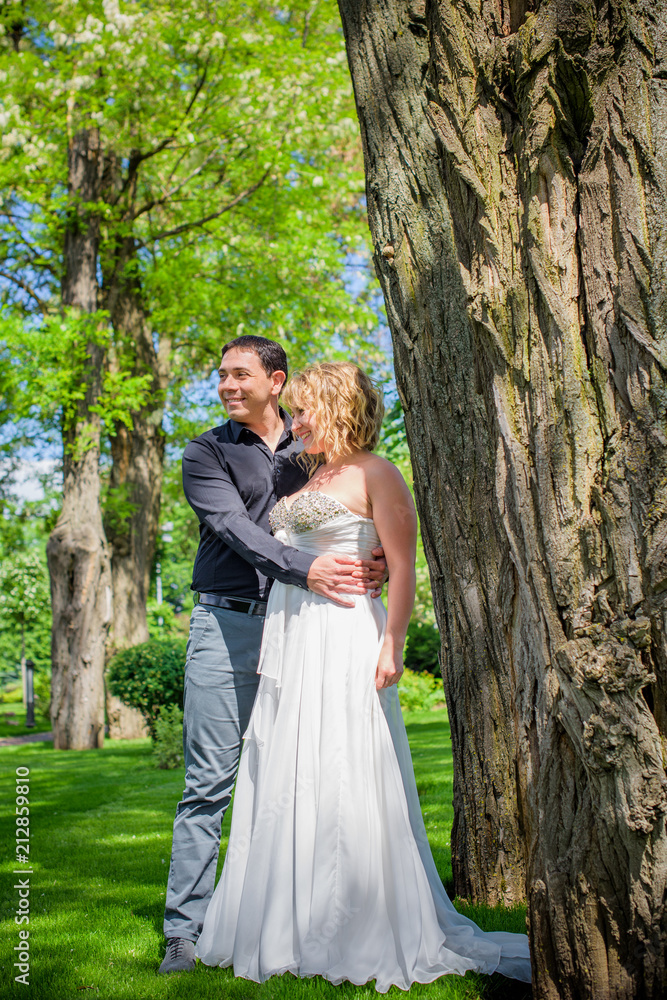 Blond bride and groom on wedding. Happy wedding couple. Beautiful bride, young woman in white dress groom kissing and having fun in outdoor on summer day. Just married, young family. 