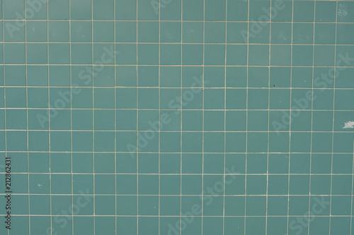 Wall surface made of green tiles. Wallpaper image of textures.