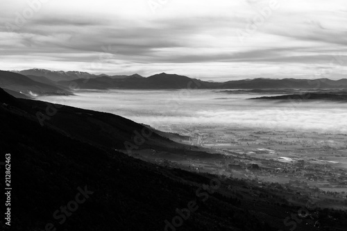 Beautiful aerial view of Umbria valley in a winter morning, with fog covering trees, houses and streets © Massimo