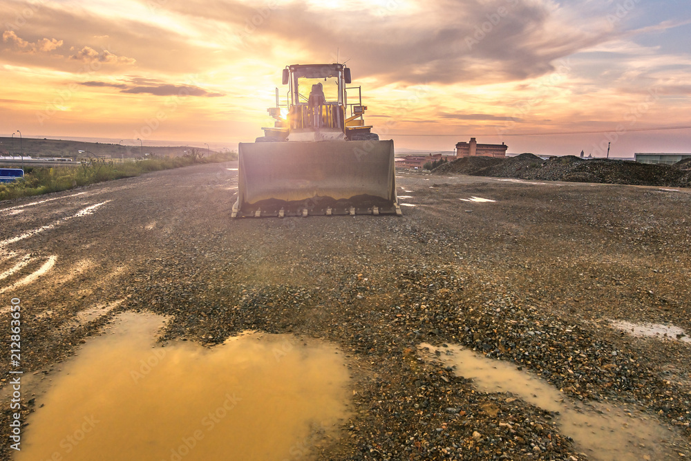 Naklejka premium Excavator at the end of a working day in a construction site