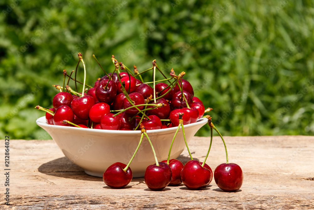 Bowl with fresh cherry on rustic wooden table outdoor Bowl with fresh cherry on rustic wooden table outdoor