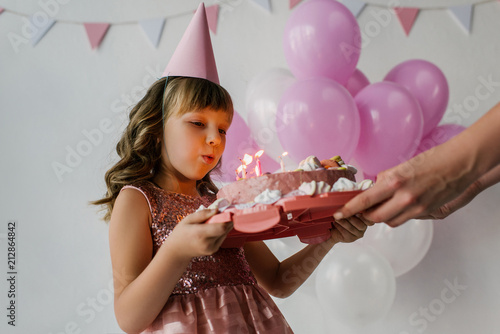 cropped image of mother holding birthday cake while child blowing out candles