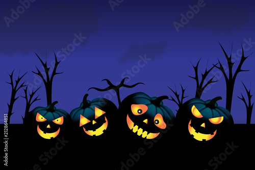 Vier leuchtende Halloween Kürbisse im Wald