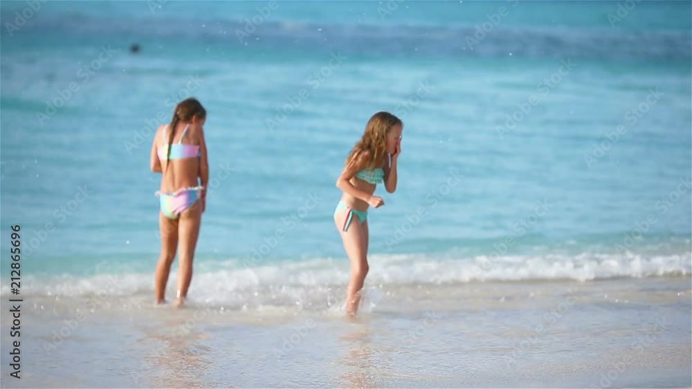 Little happy kids have a lot of fun at tropical beach playing together Little happy kids have a lot of fun at tropical beach playing together