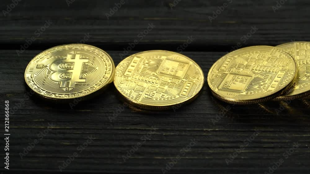 Bitcoins fall on the dark boards. Close up Bitcoins fall on the dark boards. Close up