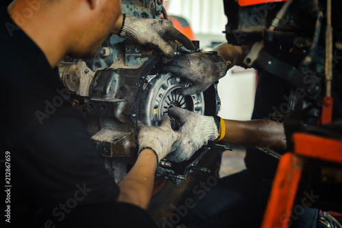 Tableau sur toile mechanic tractor working under the car and changing clutch at car repair shop tr