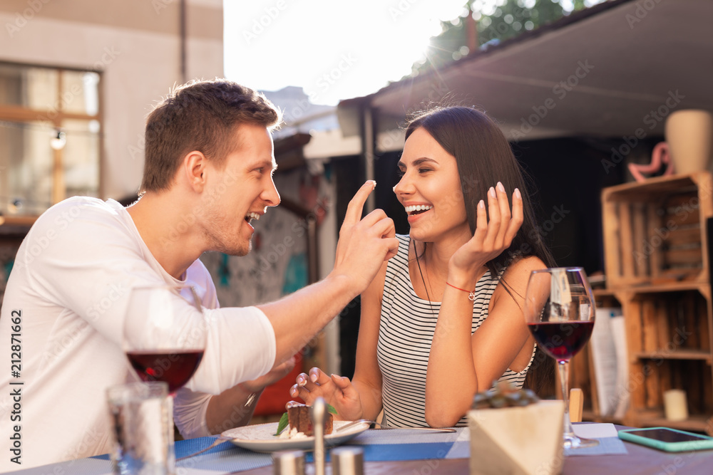 Laughing together. Blonde-haired handsome man laughing out loud along with his appealing woman Laughing together. Blonde-haired handsome man laughing out loud along with his appealing woman
