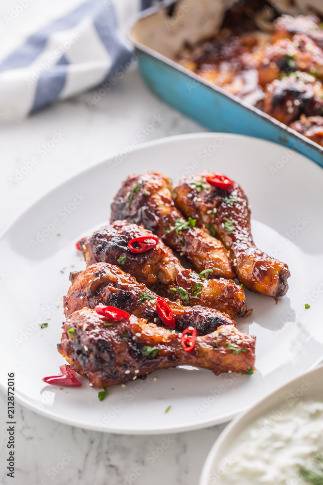 Grilled roasted and barbecue chicken legs on white plate Grilled roasted and barbecue chicken legs on white plate