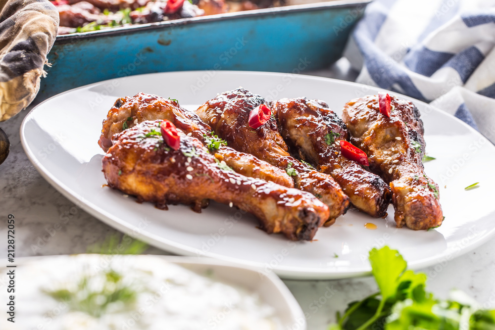 Grilled roasted and barbecue chicken legs on white plate. Grilled roasted and barbecue chicken legs on white plate.
