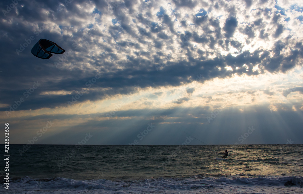 kitesurfer rides a kite-surf on waves of the sea kitesurfer rides a kite-surf on waves of the sea