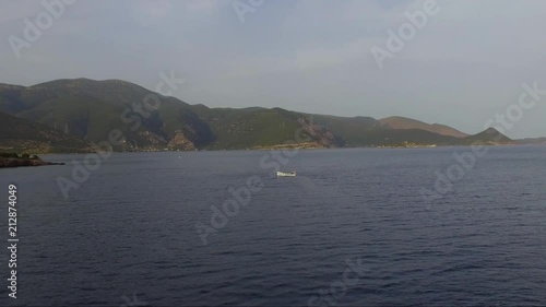 Aerial shot over the sea. Fishing boat in the horizon. Travel across islands. photo